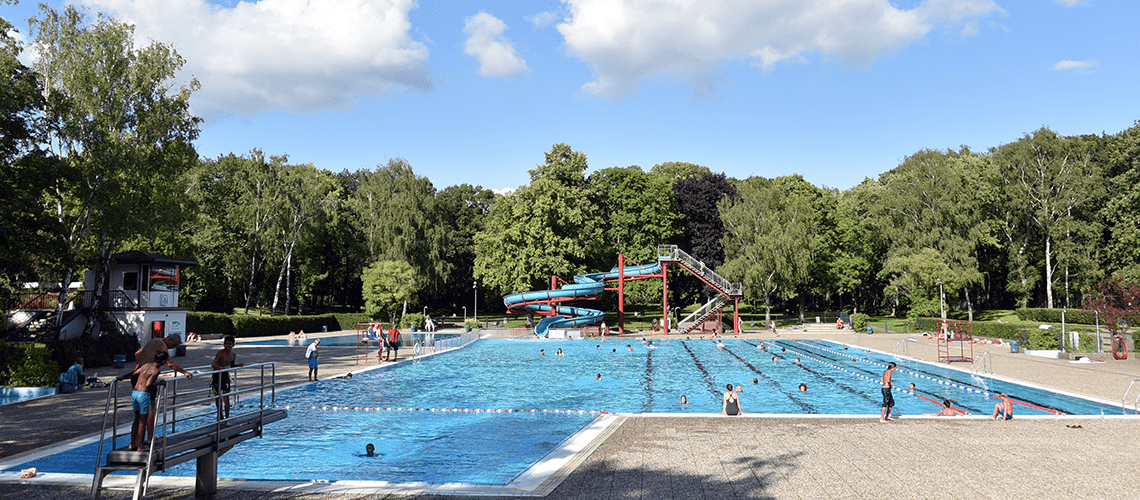 Badegäste im Schwimmbecken mit Rutsche