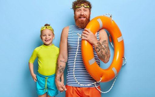 Mann mit Rettungsring und Kind mit Schwimmbrille