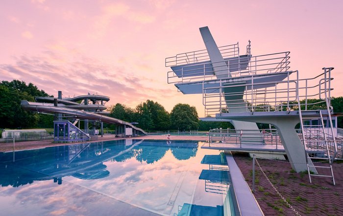 Sprungturm mit Wasserrutsche im Hintergrund