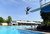 Kombibad Spandau Süd - Sommerbad. Außenbecken mit Sprungturm. Junger Mann macht Salto vom 3 Meter Sprungbrett. Im Hintergrund Badegäste im Wasser.