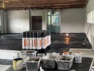 Blick in einen Raum, in dem schwarze Farbe auf den Boden aufgetragen wird zur Abdichtung