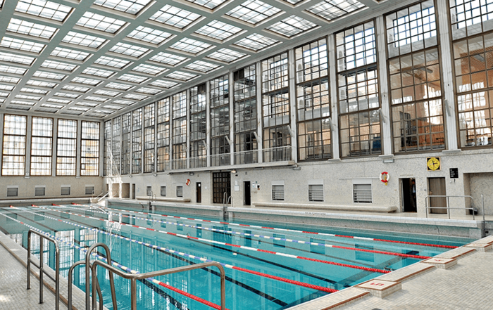 Schwimmbecken in einer großen Halle mit Fenster an den Seiten und auf dem Dach