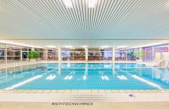 Nichtschwimmerbecken mit Kinderwasserrutsche im Hintergrund Cafeteria