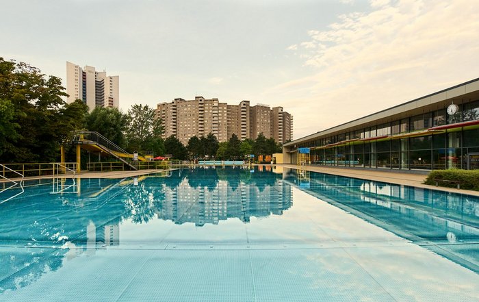 Kombibad Gropiusstadt Schwimmbecken mit Hochhäusern im Hintergrund
