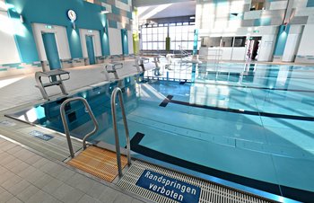 Beckenrand mit Einstieg und Startblöcken im Hintergrund - Schwimmhalle Ernst-Thälmann-Park