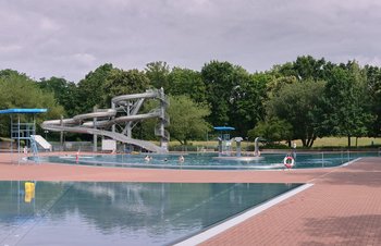 Nichtschwimmerbecken mit Rutsche im Hintergrund