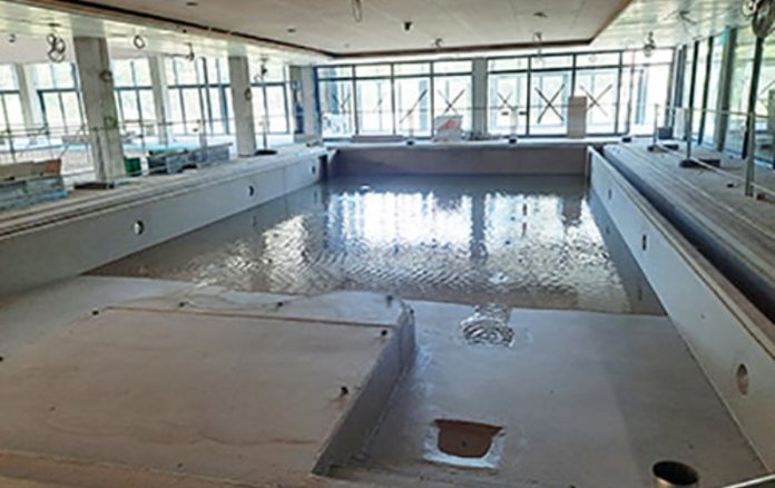 Blick in das Nichtschwimmerbecken ohne Fließen mit etwas Wasser drin